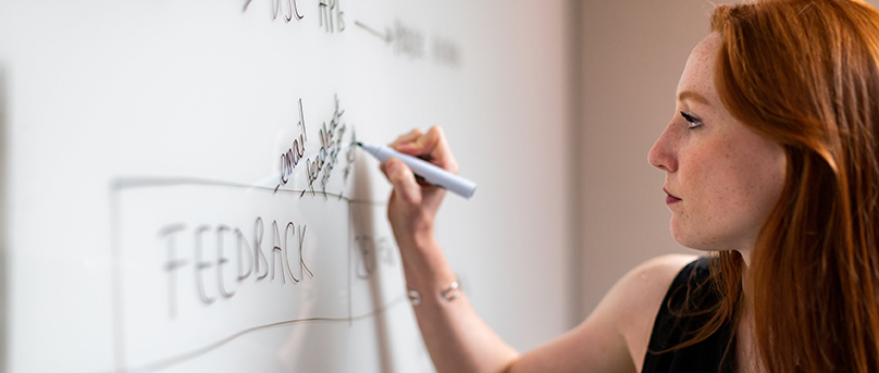 Woman writing on a white board